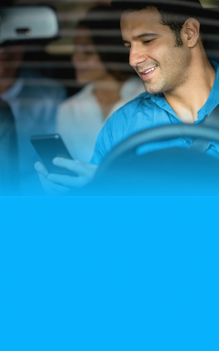 Motorista de aplicativo sorrindo enquanto acessa online informações sobre crédito com veículo como garantia. 